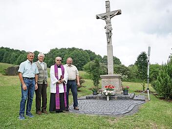 Familie Söder kümmert sich um das "weiße Kreuz" oberhalb von Sandberg. Die Restaurierung und Neugestaltung der Anlage wurde mit einem kleinen Fest zum 60-jährigen Jagdjubiläum von Gustav Söder verbunden (von links): stellvertretender Bürgermeister Claus Kleinhenz, Gustav Söder, Pfarrer Hubert Grütz und Wolfgang Söder.  Foto: Marion Eckert