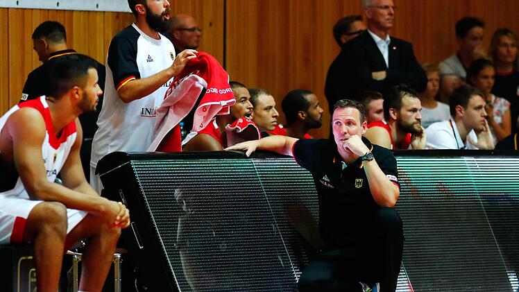 Sein Debüt in der A-Nationalmannschaft gab der aus Bamberg nach Ludwigsburg gewechselte Johannes Thiemann (links). Von Bundestrainer Chris Fleming (kniend) wurde er bereits nach wenigen Minuten eingewechselt. Foto: Daniel Löb/dpa