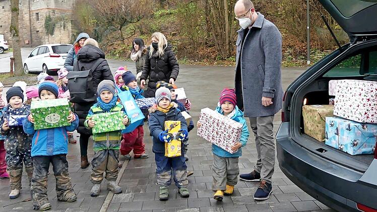 Stolz präsentieren die Kleinen der Trebgaster Kita ihre Päckchen, bevor sie von Round Table-Mitglied Florian Drechsler (rechts) eingeladen werden.