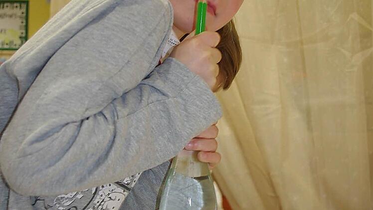 Max Schmidt bei einem Versuch in der Forscher-Ecke. Wenn er auf die Flasche - wie hier mit einem Stift - Druck ausübt, sinkt ein "Wasserteufel" zu Boden. Foto: Heike Schülein