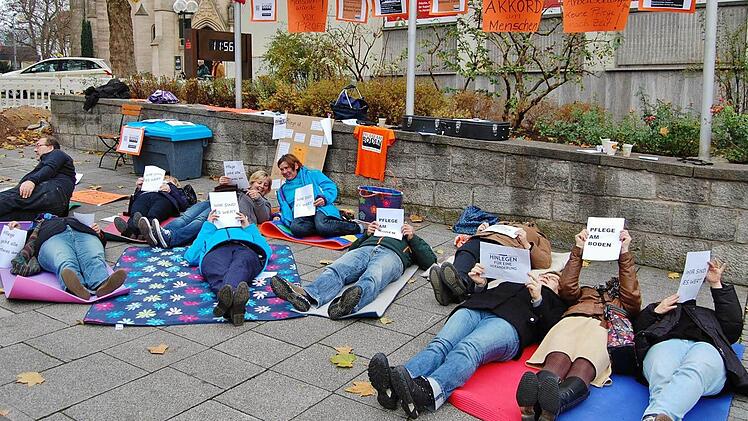 Ein Dutzend Pflegekräfte aus den Landkreisen Bad Kissingen und Rhön-Grabfeld legten sich stellvertretend für alle Kollegen auf den kalten Boden