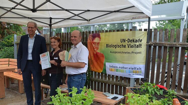 Bürgermeister German Hacker, Umweltbeauftragte Monika Preinl und VHS-Leiter Oliver Kundler mit Urkunde und dem "Vielfalt-Baum"