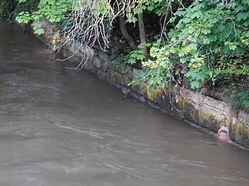 Deutlich gesunken ist am Dienstagvormittag der Pegel der Itz beim Blick von der Brücke in der Bahnhofstraße. Das Abflussrohr in der Ufermauer war noch am Vortag völlig in den braunen Fluten versunken.Foto: Jochen Berger