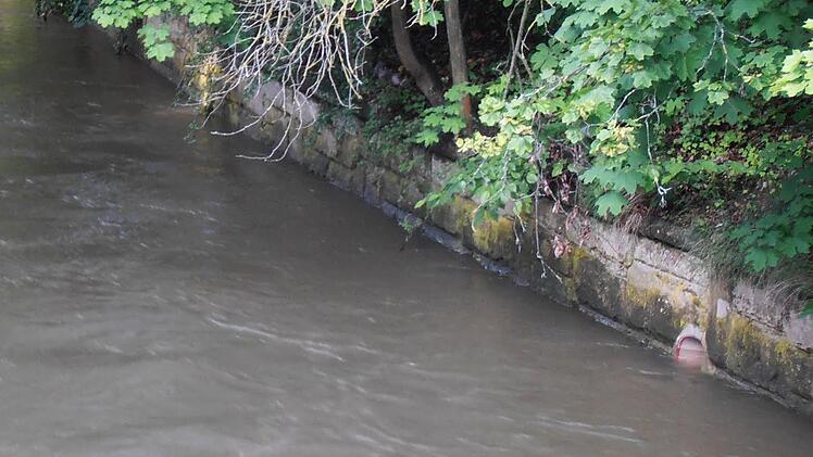 Deutlich gesunken ist am Dienstagvormittag der Pegel der Itz beim Blick von der Brücke in der Bahnhofstraße. Das Abflussrohr in der Ufermauer war noch am Vortag völlig in den braunen Fluten versunken.Foto: Jochen Berger
