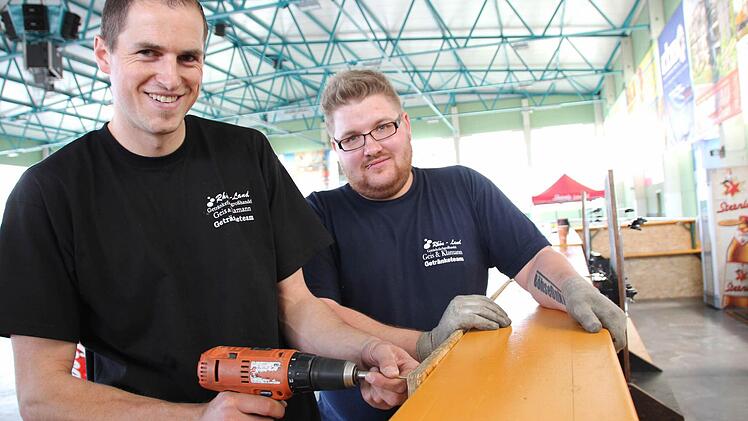 Nico (links) und Sven bauen am Freitag die Getränketheke in der Eishalle auf.  Fotos: Benedikt Borst