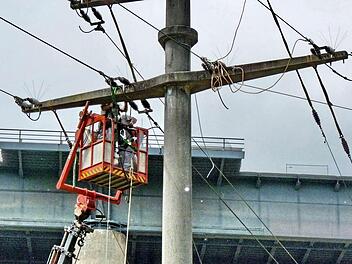 Die Stromleitungen werden gerade abgenommen, im Hintergrund ist die alte Sinntalbrücke zu erkennen, die am Samstag gesprengt wird. Fotos: Thomas Dill/Norbert Hildmann