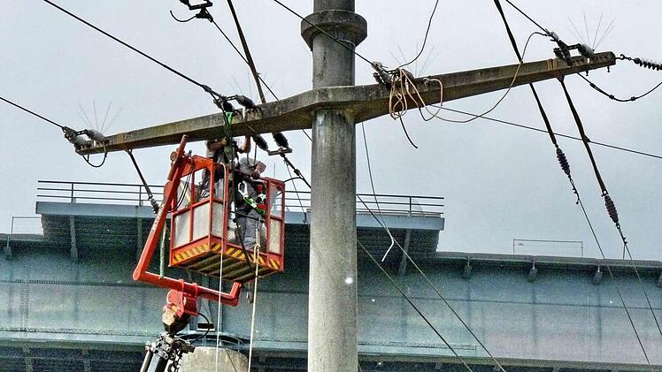 Die Stromleitungen werden gerade abgenommen, im Hintergrund ist die alte Sinntalbrücke zu erkennen, die am Samstag gesprengt wird. Fotos: Thomas Dill/Norbert Hildmann