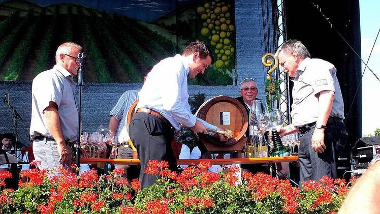 Auch bei einem Weinfest gibt es einen Anstich, zeigen die Sander. Landtagsabgeordneter Steffen Vogel zapft symbolisch das erste Fass Rotwein an.