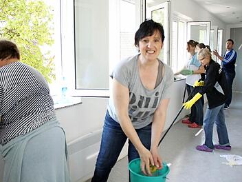 Putztag im Gemeindehaus: Auf der Baustelle im Vereinsheim Althausen wringt Margit Brust (Mitte) ein Wischtuch aus. Am 1. Mai soll hier alles fertig sein, dann richtet der Musikverein im frisch sanierten Vereinsheim seine Kaffeebar ein. Foto: Heike Beudert