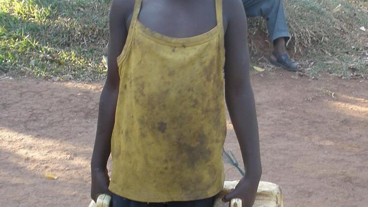 Kinder in Uganda müssen Wasser mit Kanistern aus weit entfernten Brunnen holen. Foto: Johanna Blum