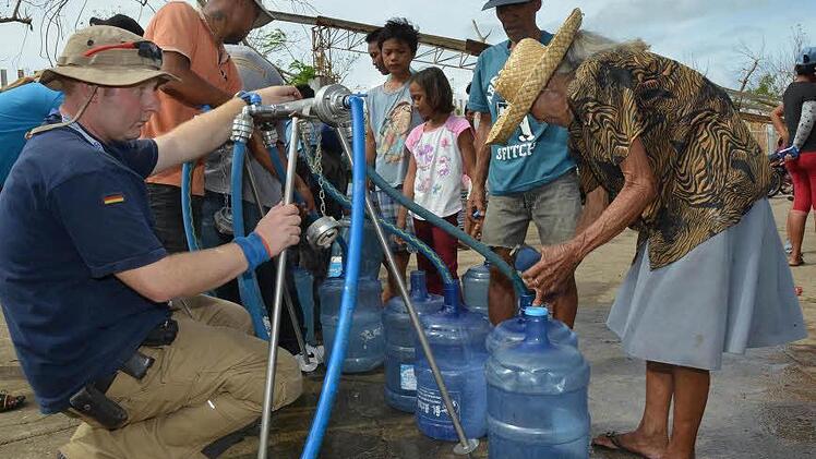 Der THW-Mitarbeiter Roman Petryckka (links) aus Coburg war bei der Brunnensanierung und somit auch bei der Wasserausgabe auf den Philippinen eingesetzt. Foto: Technisches Hilfswerk