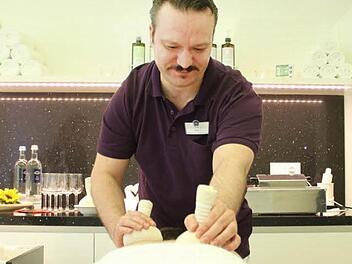 Masseur Cüneyt "Cino" Ünlüer demonstriert im "Vitus Spa" an seinem Kollegen Christoph Graf die Behandlung mit Kräuterstempeln. Fotos: Thomas Heuchling