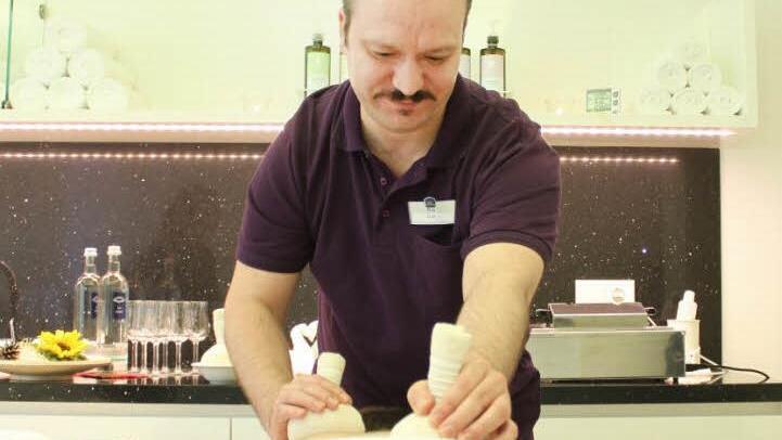 Masseur Cüneyt "Cino" Ünlüer demonstriert im "Vitus Spa" an seinem Kollegen Christoph Graf die Behandlung mit Kräuterstempeln. Fotos: Thomas Heuchling