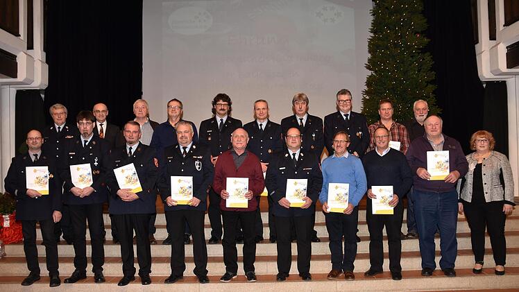 Die Inhaber der Bayerischen Ehrenamtskarte in Gold wurden in der Stadthalle Haßfurt auch mit der Dankurkunde des Landkreises ausgezeichnet. Unser Bild zeigt die Geehrten der Feuerwehren Haßfurt und Lembach sowie Landrat Wilhelm Schneider (hinten, Zweiter von links) und Monika Strätz-Stopfer, Leiterin des Koordinierungszentrums Bürgerschaftliches Engagement am Landratsamt (vorne, rechts).U. Langer