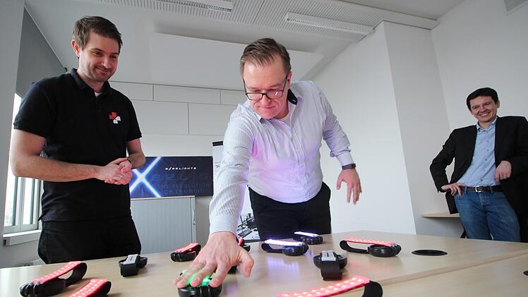 Fang das Licht! - Geschäftsführer und Software-Experte Achim Schmidt (Mitte) macht vor, wie eine der spielerischen Aufgaben aussehen könnte, mit denen das Forchheimer Start-up Exerlights Health älteren Pflegebedürftigen helfen will. Sein Kollege Stefan Deuerling (links) leitet diese Spielrunde. Wirtschaftsförderer Viktor Naumann hält das gemeinschaftliche Projekt für ein gutes Beispiel für die wirtschaftliche Zukunft Forchheims.  Foto: Ronald Heck