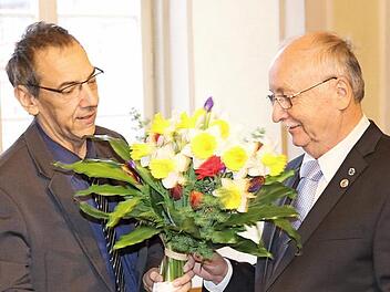 Dritter Bürgermeister Thomas Nowak dankt Hubert Joppich mit der Medaille und mit Blumen.