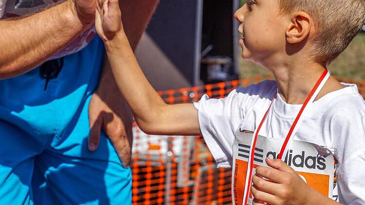 Tenilin Dmitry (re.) wird zu seinem Zieleinlauf beglückwünscht.