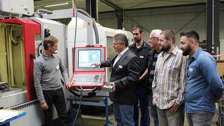 Johann Kraus (2. v. l.) mit einigen seiner Mitarbeiter an einer Fräsmaschine   Yannick Hupfer