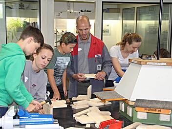 Unter Anleitung von Ausbildungsleiter Stephan Walter (Zweiter von rechts) und Azubis der Firma FTE, bauten Kinder in der Lehrwerkstatt der Firma Nistkästen.  Foto: Helmut Will