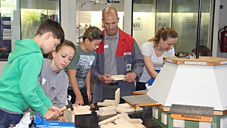 Unter Anleitung von Ausbildungsleiter Stephan Walter (Zweiter von rechts) und Azubis der Firma FTE, bauten Kinder in der Lehrwerkstatt der Firma Nistkästen.  Foto: Helmut Will