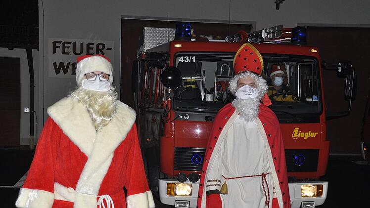 Mit zwei Feuerwehrautos waren die Nikoläuse der Reiterswiesener Feuerwehr unterwegs, um Kindern in ihrem Stadtteil am Nikolaustag eine Freude zu bereiten. Foto: Peter Klopf