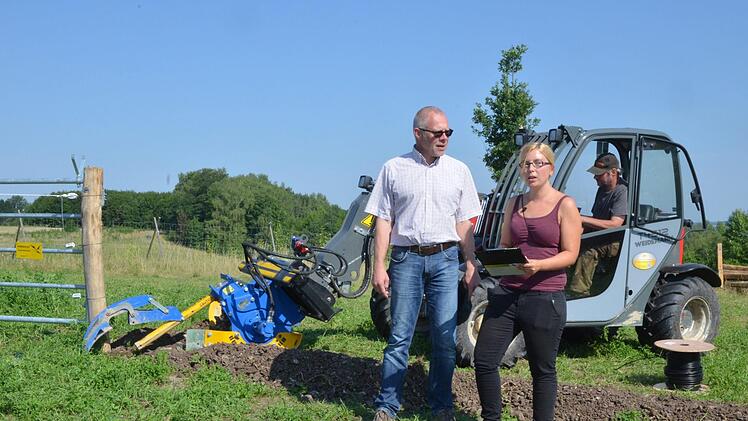 Frank Reißenweber und Janine Schindhelm machen sich ein Bild von den Arbeiten am Zaun.