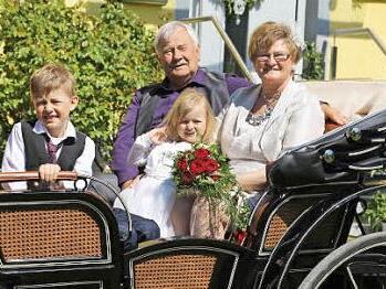 Das Jubelpaar sitzt mit zwei Enkelkinder in der Kutsche.  Foto: Franz Galster