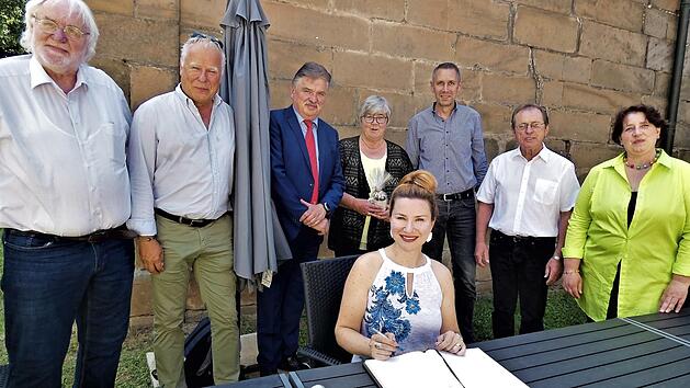 Ekatarina Gubanova trägt sich in das Gästebuch des Marktes Thurnau ein. Dahinter stehend von links Zweiter Bürgermeister Veit Pöhlmann, Peter Fraas, Landrat Klaus Peter Söllner, Gemeinderätin Brigitte Soziaghi, Bürgermeister Martin Bernreuther, Gemeinderat Erwin Schneider und Gemeinderätin Dunja Pfaffenberger.