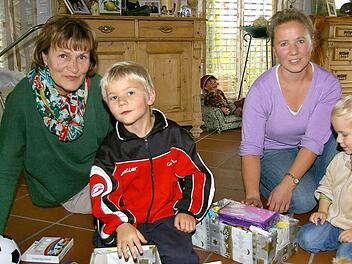 Jetzt kann Weihnachten kommen. Ismael (6 ) und Raul (3 ) haben die ersten Schuhkartons gepackt. Renate Strung (links) und Maria Fast beaufsichtigen die Aktion.  Fotos: Tom Müller
