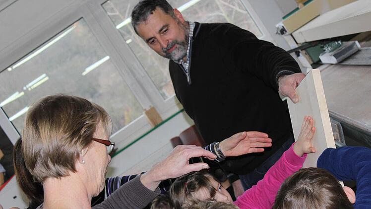 Ganz schön glatt: Die Kinder überzeugen sich davon, dass die Schleifmaschine von Manfred Finger ganze Arbeit geleistet hat. Foto: Nina Grötsch