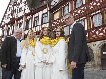 Flankiert von Bürgermeister Franz Streit (l.) und Oberbürgermeister Uwe Kirschstein (r.) präsentieren sich Laura Schmidt (zweite v.l.), Johanna Schaffner (Mitte) und Nina Biermann vor dem Rathaus, das sich bald in den schönsten Adventskalender der Welt verwandeln wird.  Foto: Oswald