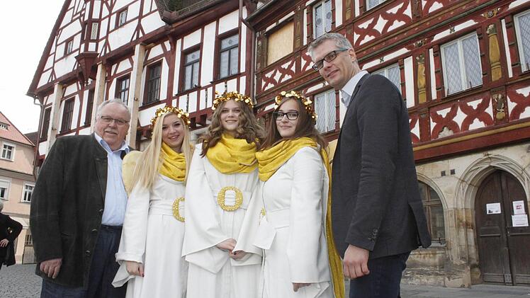 Flankiert von Bürgermeister Franz Streit (l.) und Oberbürgermeister Uwe Kirschstein (r.) präsentieren sich Laura Schmidt (zweite v.l.), Johanna Schaffner (Mitte) und Nina Biermann vor dem Rathaus, das sich bald in den schönsten Adventskalender der Welt verwandeln wird.  Foto: Oswald
