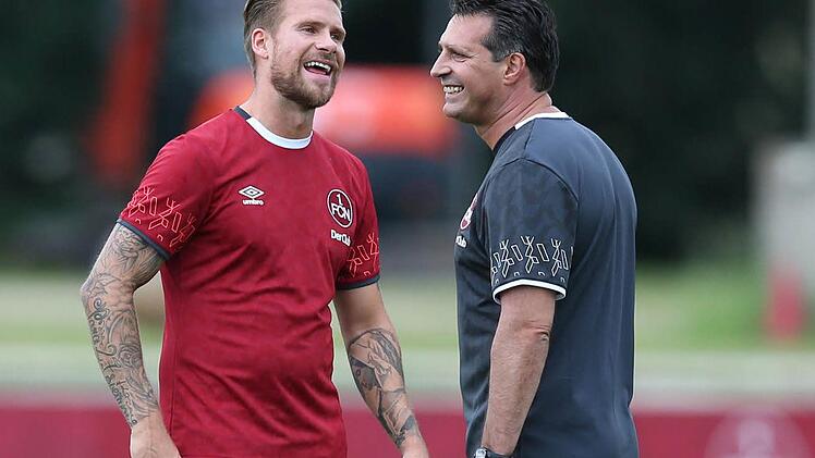 Club-Trainer Alois Schwartz (r.) scherzt während einer Trainingseinheit mit Neuzugang Tobias Kempe. Foto: Daniel Karmann/dpa