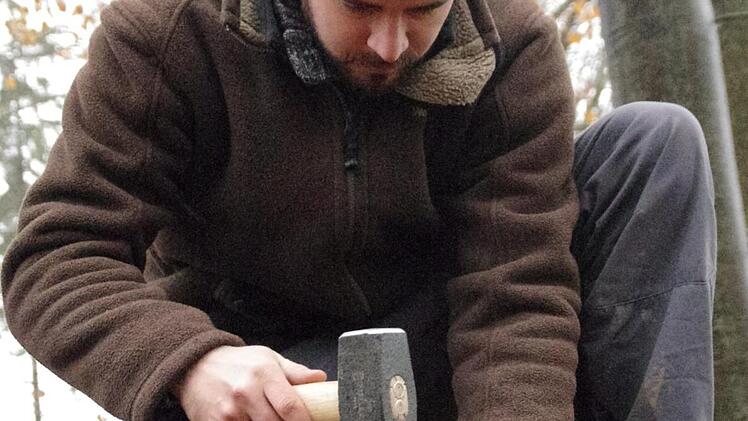 Philipp Schinkel versenkt einen der für die Untersuchungen wichtigen Markierungsstifte im Waldboden.