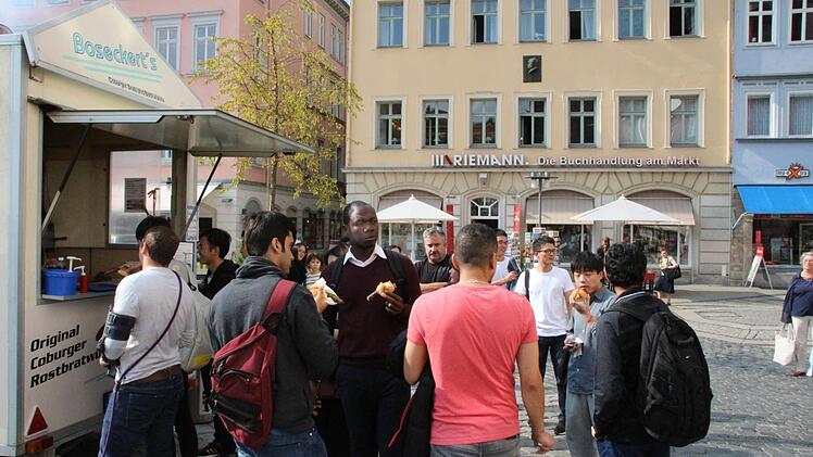 Die internationalen Studenten begannen ihr Auslandssemester au f dem Markt mit einem kräftigen Biss in eine lokale Spezialität - die Coburger Bratwurst.  Fotos: Christian Dreßel