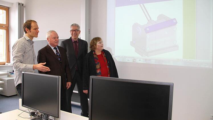 (v. l.) Oberstudienrat Oliver Daum mit dem stellvertretenden Landrat Helmut Fischer, Schulleiter Hans-Jürgen Lichy und Agenturchefin Brigitte Glos in einer Klasse für technische Produktdesigner.  Foto: Gerda Völk