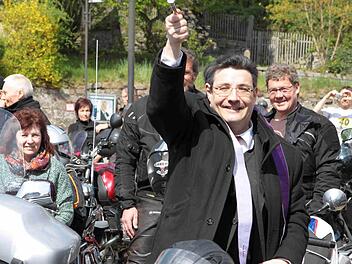 Pfarrer Michael Krammer hat viel Spaß beim Segnen der Maschinen. "Wer Angst um seinen Chrom hat, möge die Maschine vor dem geweihten Wasser schützen", betonte fürsorglich der Geistliche. Foto: Thomas Dill