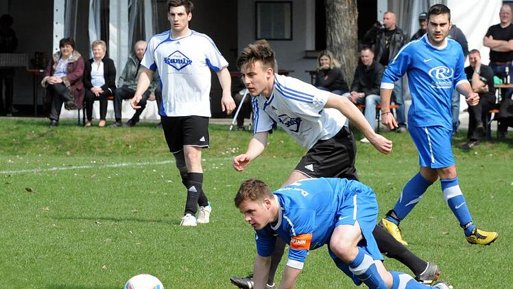 Die DJK Kothen strauchelt in Poppenroth: FCler Tobias Kröckel (Mitte) nimmt DJK-Spielführer Manuel Bug die Kugel ab. Rechts Georg Schwarz (Kothen) und links hinten Martin Kleinhenz (Poppenroth). Foto: Hopf