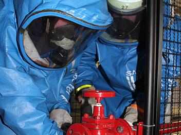 In der Atemschutzstrecke bauen die Feuerwehrler einen Schieber aus. Gar nicht so einfach mit den schweren Schutzhandschuhen und den flüssigkeits- und gasdichten Anzügen.  Fotos: Sonja Adam