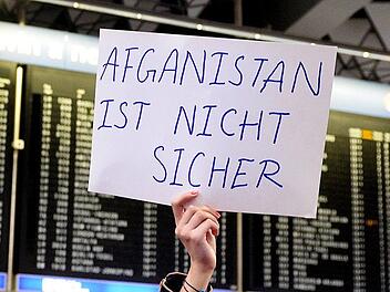 Am Flughafen in Frankfurt am Main h&auml;lt eine Demonstrantin ein Schild gegen die Abschiebung Gefl&uuml;chteter nach Afghanistan in die H&ouml;he. Am Mittwoch h&auml;tte ein weiterer Flieger von Frankfurt nach Kabul starten sollen. Wegen eines Anschlags mit mehr als 80 Toten am Mittwoch in der afghanischen Hauptstadt hat das Innenministerium den Flug gestoppt. Symbolbild: Susann Prautsch/ dpa