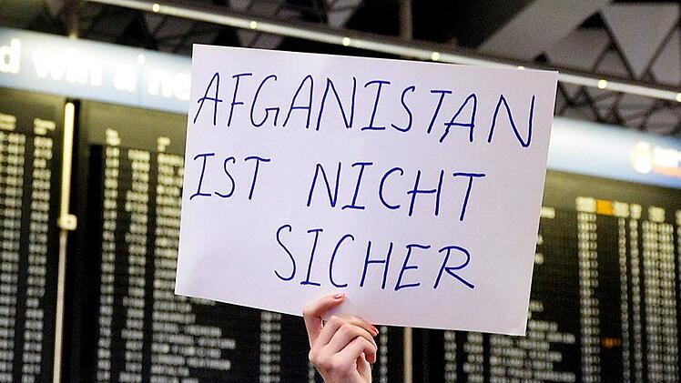 Am Flughafen in Frankfurt am Main hält eine Demonstrantin ein Schild gegen die Abschiebung Geflüchteter nach Afghanistan in die Höhe. Am Mittwoch hätte ein weiterer Flieger von Frankfurt nach Kabul starten sollen. Wegen eines Anschlags mit mehr als 80 Toten am Mittwoch in der afghanischen Hauptstadt hat das Innenministerium den Flug gestoppt. Symbolbild: Susann Prautsch/ dpa