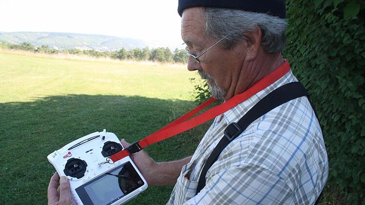 Der Copterpilot Markus Kuschel erklärt die Fernbedienung seines Multicopters: Ein großes Display für die Kamera Bilder und Flugdaten und auf Knopfdruck kehrt das mit GPS ausgestattete Model zum Ort des Abflugs zurück.  Foto: Sebastian Elsässer