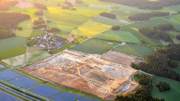 Der Ort Feulersdorf (Hintergrund, links) wirkt im Vergleich zur Großbaustelle geradezu mickrig. Zwölf Hektar groß ist die Fläche, auf der seit vielen Wochen die Erdarbeiten für die Gemüsefarm laufen. Zwischen den Photovoltaik-Anlagen ist die A 70 zu sehen. Fotos: Axel Emersleben