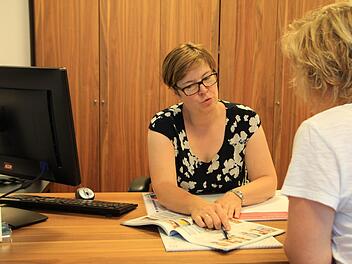 Astrid Dresel zeigt in einem Reisekatalog Beispiele für den nächsten Urlaub: Foto: Franziska Rieger