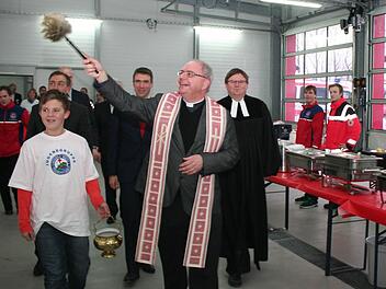 Mit Gottes Segen können jetzt die vielen haupt- und ehrenamtlichen BRK-Mitarbeiter an ihre Einsätze gehen. Dekan Kilian Kemmer (vorne) und Pfarrer Fritz Schäfer segneten die Fahrzeughalle und die neuen Räume.  Foto: Evi Seeger