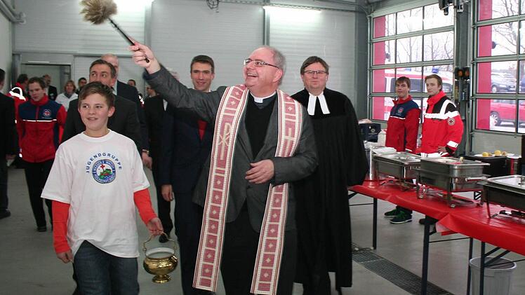 Mit Gottes Segen können jetzt die vielen haupt- und ehrenamtlichen BRK-Mitarbeiter an ihre Einsätze gehen. Dekan Kilian Kemmer (vorne) und Pfarrer Fritz Schäfer segneten die Fahrzeughalle und die neuen Räume.  Foto: Evi Seeger