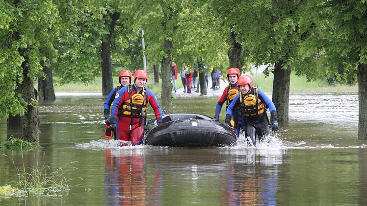 Die Straße nach Ebersbach ist wegen des Hochwassers für den Rettungswagen nicht passierbar. Wasserretter simulieren hier, wie sie einen "Patienten" mit dem Schlauchboot abholen und an der Straße an den Rettungsdienst übergeben. Im Ernstfall und bei noch stärkerer Strömung würden Helfer und Boot mit Leinen zusätzlich gesichert. Fotos: Katrin Geyer
