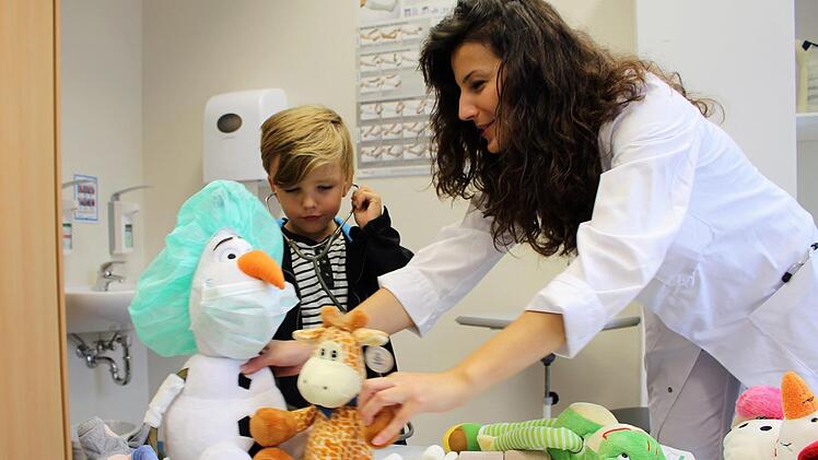 Max Walter untersucht mit Hilfe der Assistenzärztin Ivana Stojanovic das Kuscheltier Schneemann Olaf.