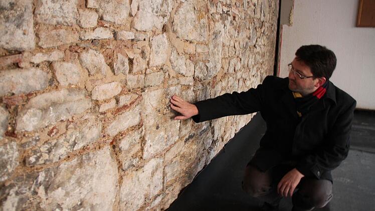 Fasziniert ist Pater Jeremias Kiesl von der historischen Mauer, die bei Renovierungsarbeiten in der Arche zum Vorschein kam. Er kann sich vorstellen, dass es ein Teil der ehemaligen historischen Stadtmauer ist, die auch die nordwestliche Altstadt einst umspannt hat.  Foto: Heike Beudert