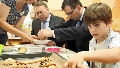 Ernährungsberaterin Brigitte Völkl hilft Ernährungsminister Helmut Brunner und MdL Martin Schöffel (von links) bei der Zubereitung von Gebäck. Christoph Koch (vorne) hat sein Werk da schon lange erledigt.